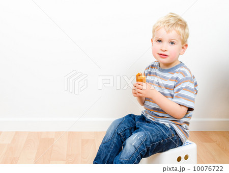 Cute little boy eating delicious cookie at home 10076722