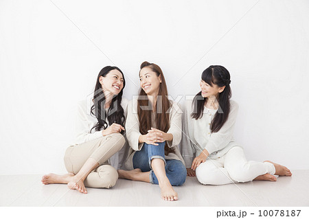床に座る女性3人の写真素材