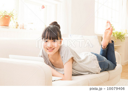 ソファに寝転ぶ女性の写真素材