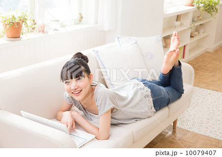 ソファに寝転ぶ女性の写真素材