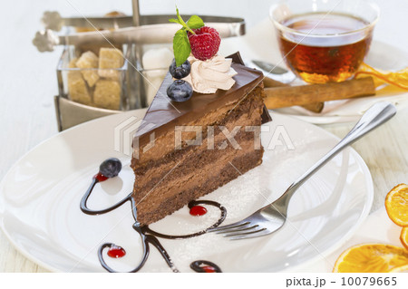 Prague piece of cake decorated with raspberries on a white background Prague piece of cake decorated with raspberries on a white background 10079665