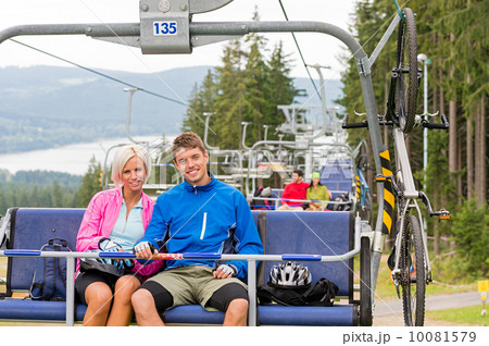 Chair lift going through forest couple sitting Chair lift going through forest couple sitting 10081579