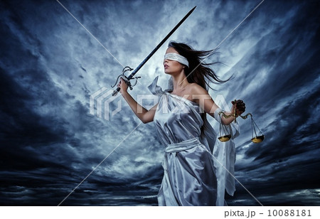 Femida, Goddess of Justice, with scales and sword wearing blindfold against dramatic stormy sky 10088181