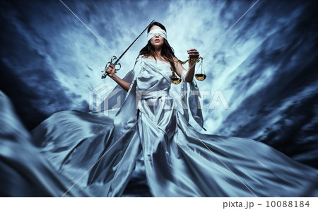 Femida, Goddess of Justice, with scales and sword wearing blindfold against dramatic stormy sky 10088184