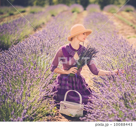 Woman in purple dress and hat with basket in lavender field Woman in purple dress and hat with basket in lavender field 10088443