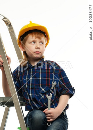 Little boy in protective helmet with wrench tool on a ladder 10088477
