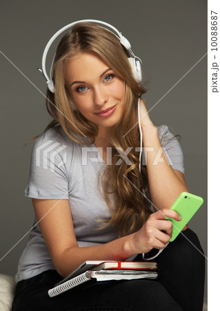 Positive woman student with notebook listens to music 10088687