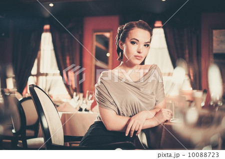 Beautiful young woman alone in a luxury restaurant interior Beautiful young woman alone in a luxury restaurant interior 10088723