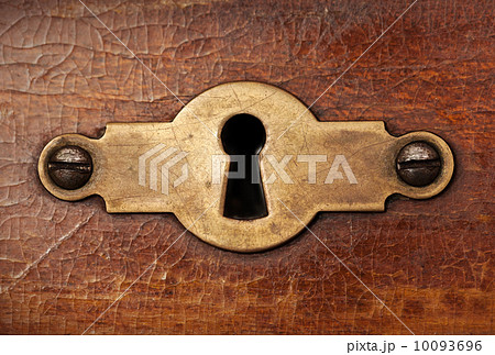 Vintage copper keyhole decorative element on weathered wooden su 10093696