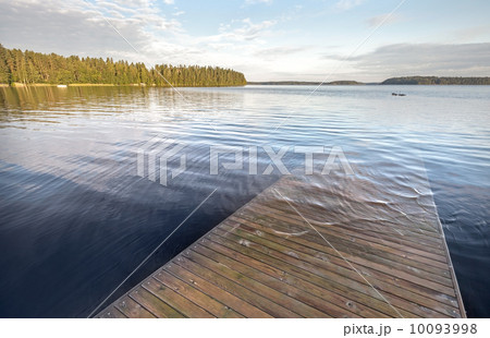 Old wooden pier goes under deep water on the lake 10093998