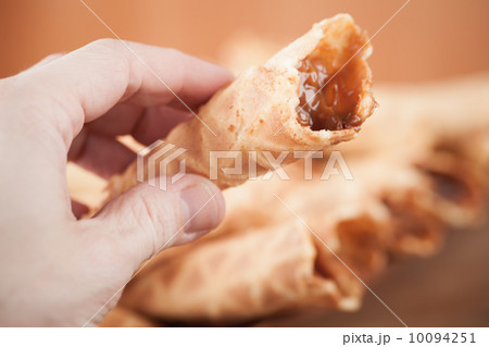 Homemade wafer cone with cream of sweet boiled condensed milk in man's hand. Traditional Russian dessert 10094251