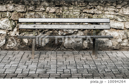 Wooden bench nearby old stone wall in the park Wooden bench nearby old stone wall in the park 10094264