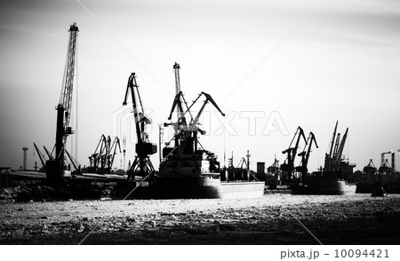 Silhouettes of cargo port skyline with cranes, ships and poles 10094421
