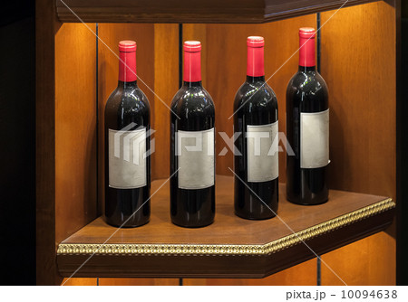 Four luxury red vine bottles on wooden shelf Four luxury red vine bottles on wooden shelf 10094638