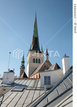 Houses with metal roofs and church St. Olaf above blue sky. Old Tallinn, Estonia 10094665