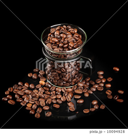 Mug made of glass with whole roasted coffee beans on black background Mug made of glass with whole roasted coffee beans on black background 10094928