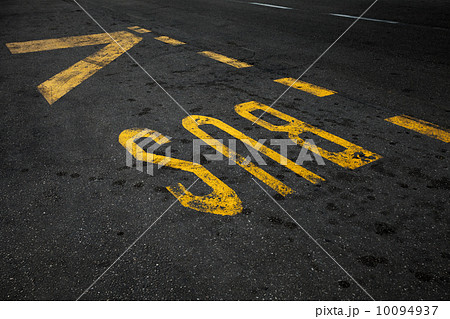Yellow bus stop marking on urban asphalt road 10094937