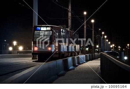 The last tram rides over a bridge on a winter night 10095164