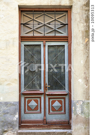 Ancient red wooden door with glass and decoration elements. Tallinn, Estonia 10095313