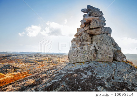 Stone cairn as a navigation mark on the top of Norwegian mountai 10095314