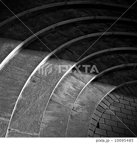 Curved footsteps made of stone with shadow walking across it 10095485