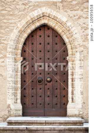 Ancient dark wooden door in old building facade. Tallinn, Estonia 10095658
