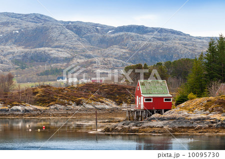 Old red wooden house stands on the sea coast in Norway Old red wooden house stands on the sea coast in Norway 10095730