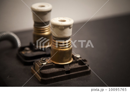 Two vintage electrical fuses on dark panel 10095765