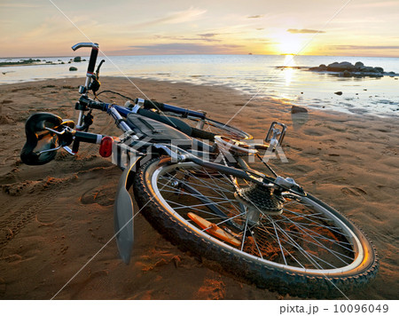 Bicycle lying on the beach 10096049