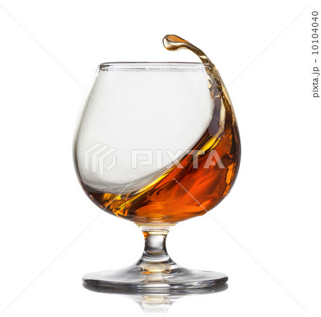 Splash of cognac in glass isolated on white background 10104040
