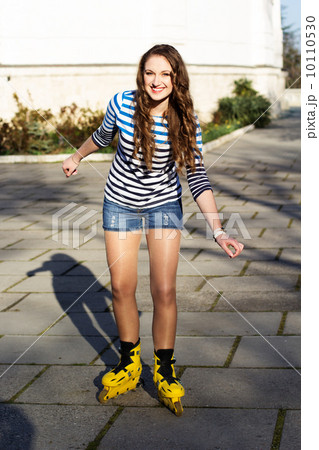 Pretty teenage girl rollerskating in park Pretty teenage girl rollerskating in park 10110530