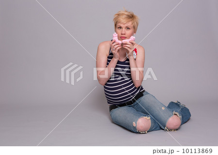 happy young pregnant woman holds a pink socks for his daughter happy young pregnant woman holds a pink socks for his daughter 10113869