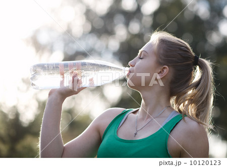 Young woman drinking water after fitness Young woman drinking water after fitness 10120123