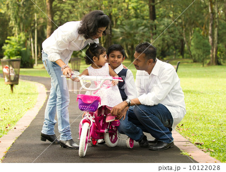 indian family teaching their kids cycling in the outdoor park 10122028