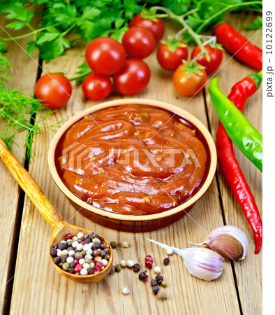 Ketchup in pottery with spices on board Ketchup in pottery with spices on board 10122699