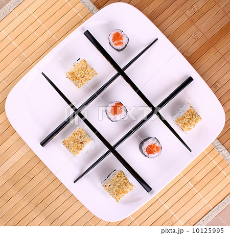 Tic tac toe play and chopsticks with sushi, close up Tic tac toe play and chopsticks with sushi, close up 10125995