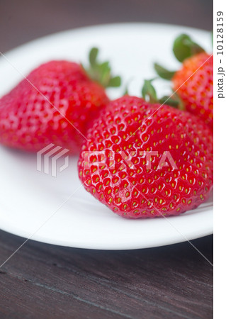 red juicy strawberry in a plate on a wooden surface red juicy strawberry in a plate on a wooden surface 10128159