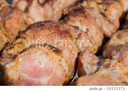 Appetizing hot shish kebab on metal skewers in a sunny day close up Appetizing hot shish kebab on metal skewers in a sunny day close up 10131573