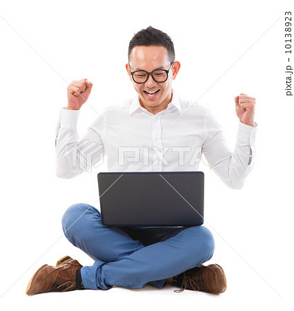 Excited Asian man using laptop 10138923