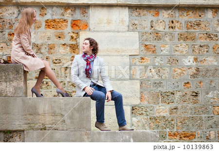 Dating couple sitting on the Seine embankment Dating couple sitting on the Seine embankment 10139863