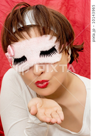 Young attractive woman in sleep mask sending kiss 10143965