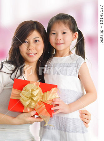 Asian girl giving a gift to her happy mother Asian girl giving a gift to her happy mother 10145127