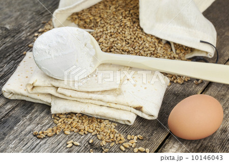 Pita bread with grains,egg and flour on old wooden table Pita bread with grains,egg and flour on old wooden table 10146043