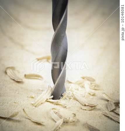 Drill drilling into the wood with sawdust around 10146081