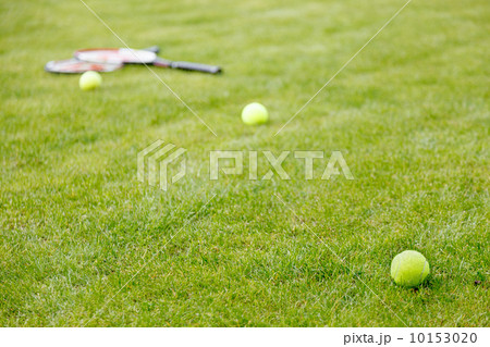 tennis ball and racket on the grass 10153020