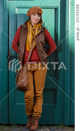 Beautiful woman standing before the closed turquoise door 10159288