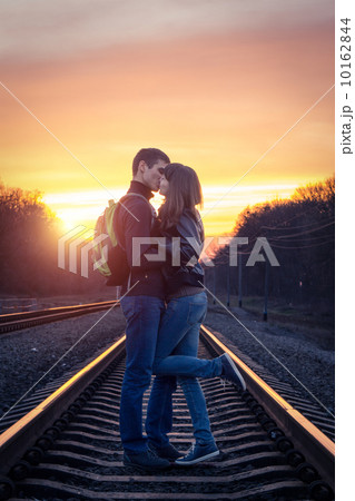 Romantic couple kissing at sunset on railroad Romantic couple kissing at sunset on railroad 10162844