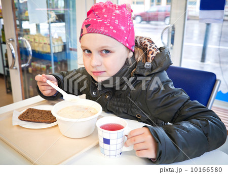 Portrait of eating little girl with spoon in a fast food restaur Portrait of eating little girl with spoon in a fast food restaur 10166580
