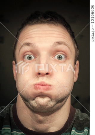 Young funny Caucasian man inflates cheeks. Closeup portrait 10166606