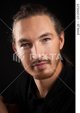 Slightly smiling young smart Oriental man portrait on black back 10166629
